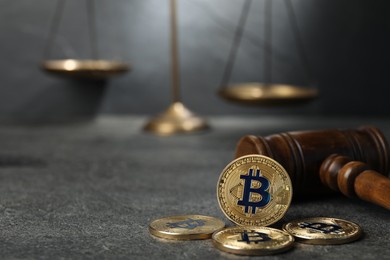 Photo of Cryptocurrency. Bitcoins, judge's gavel and scales on grey table, closeup. Space for text