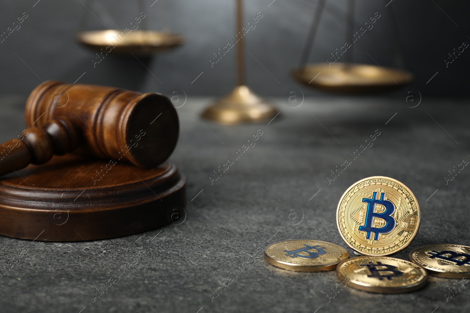 Photo of Cryptocurrency. Bitcoins, judge's gavel and scales on grey table, closeup