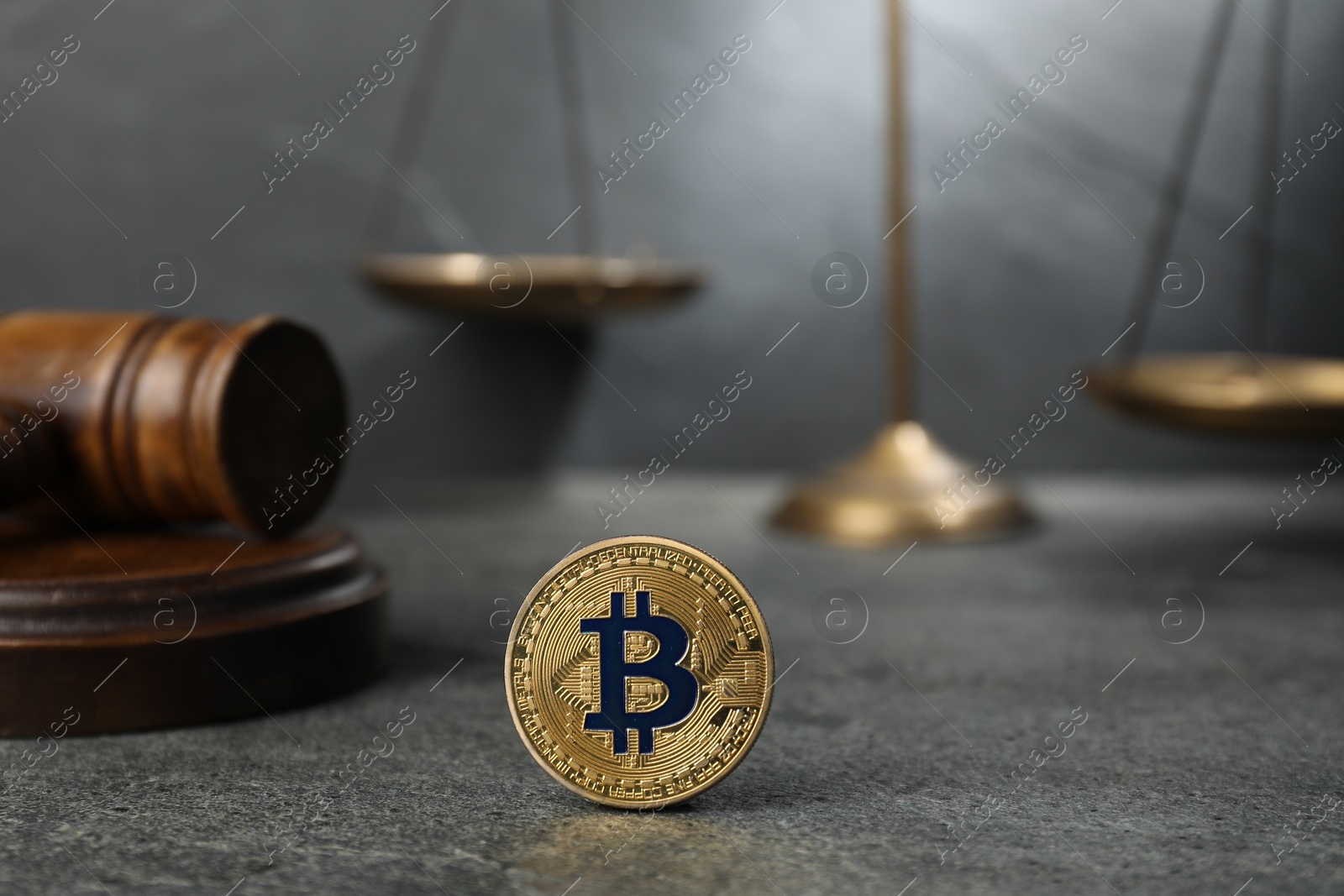 Photo of Cryptocurrency. Bitcoin, judge's gavel and scales on grey table, closeup