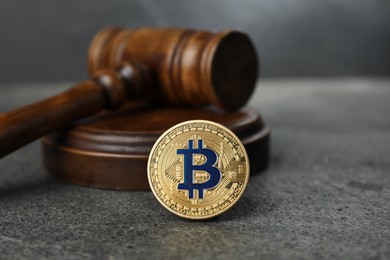 Photo of Cryptocurrency. Bitcoin and judge's gavel on grey table, closeup