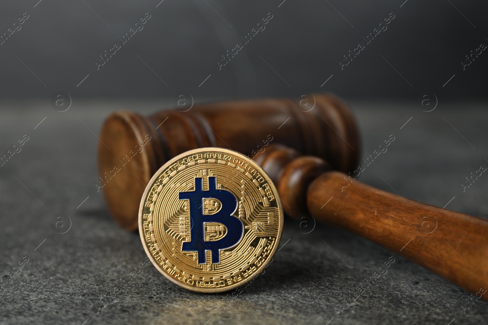Cryptocurrency. Bitcoin and judge's gavel on grey table, closeup Photo of Cryptocurrency. Bitcoin and judge's gavel on grey table, closeup