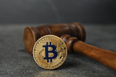 Photo of Cryptocurrency. Bitcoin and judge's gavel on grey table, closeup