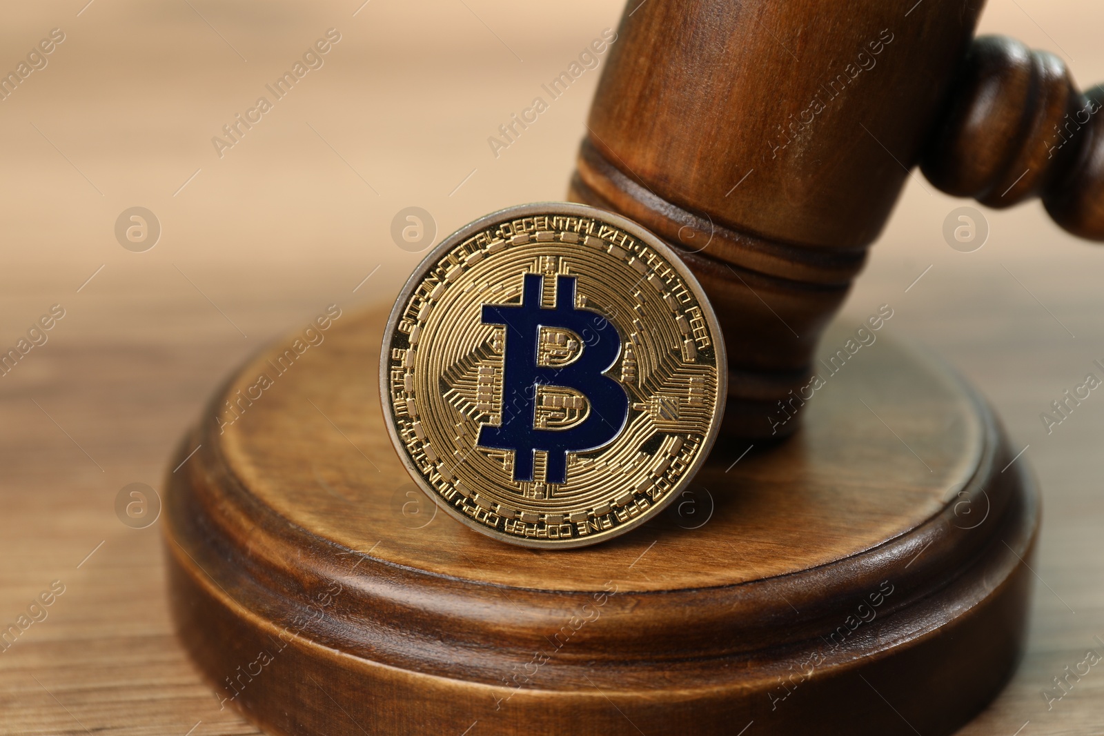 Cryptocurrency. Bitcoin and judge's gavel on wooden table, closeup Photo of Cryptocurrency. Bitcoin and judge's gavel on wooden table, closeup