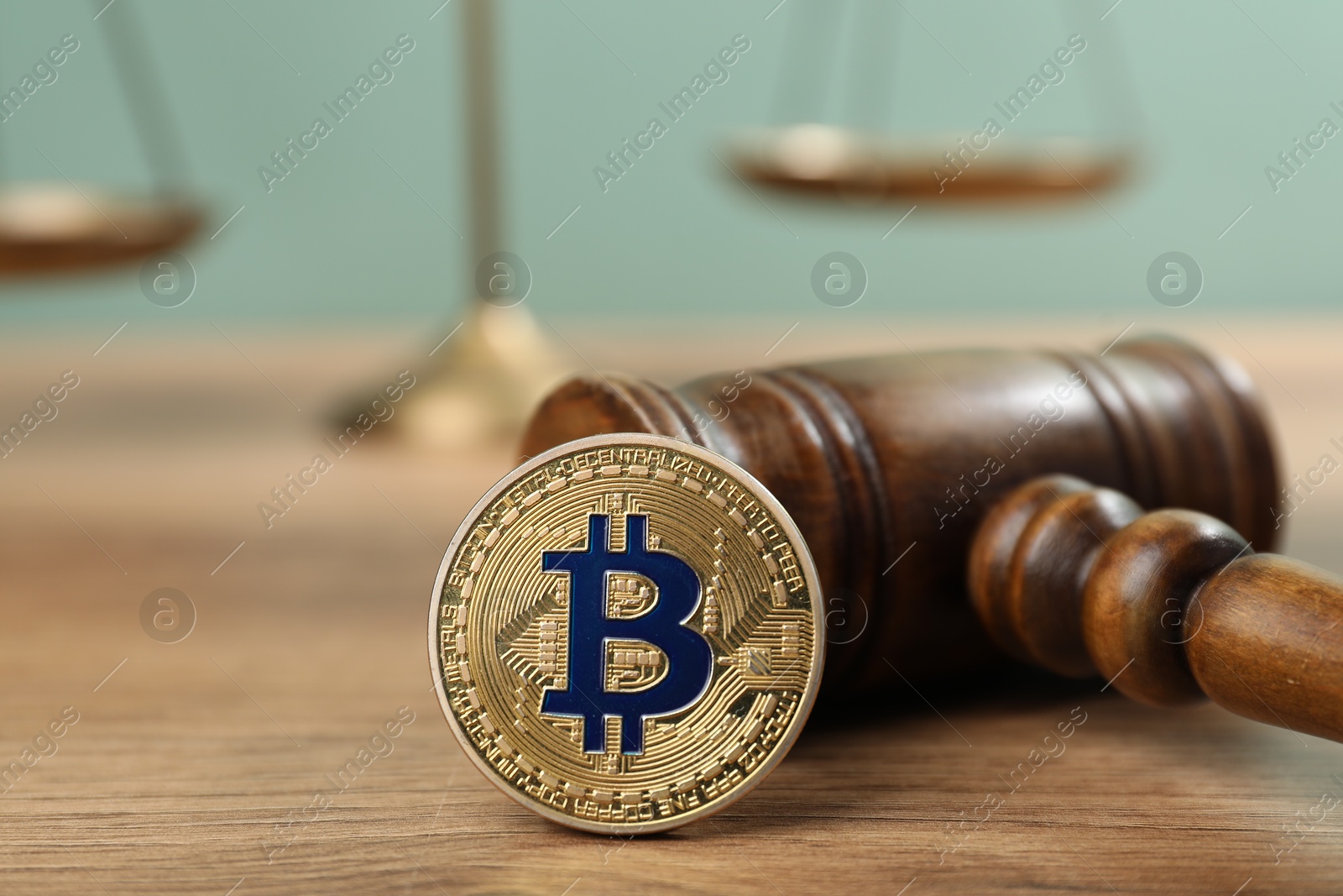 Cryptocurrency. Bitcoin, judge's gavel and scales on wooden table, closeup Photo of Cryptocurrency. Bitcoin, judge's gavel and scales on wooden table, closeup