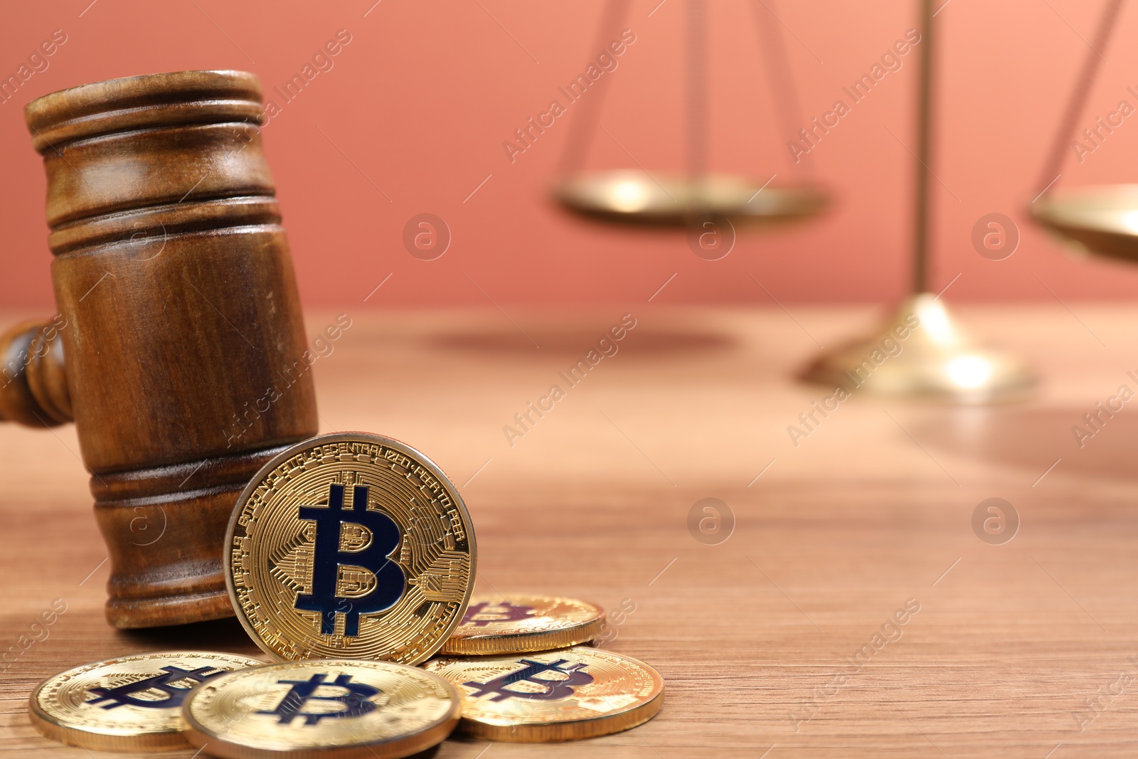 Photo of Cryptocurrency. Bitcoins, judge's gavel and scales on wooden table, closeup. Space for text