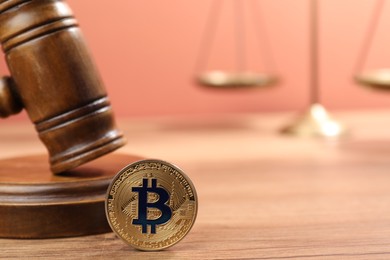 Photo of Cryptocurrency. Bitcoin, judge's gavel and scales on wooden table, closeup. Space for text