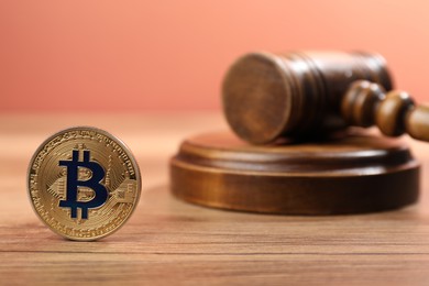 Photo of Cryptocurrency. Bitcoin and judge's gavel on wooden table, closeup