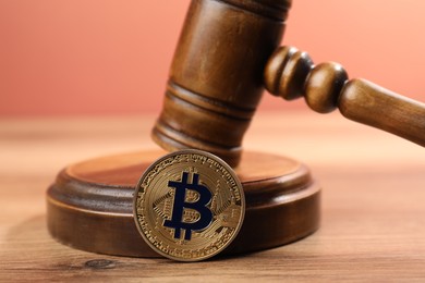 Photo of Cryptocurrency. Bitcoin and judge's gavel on wooden table, closeup