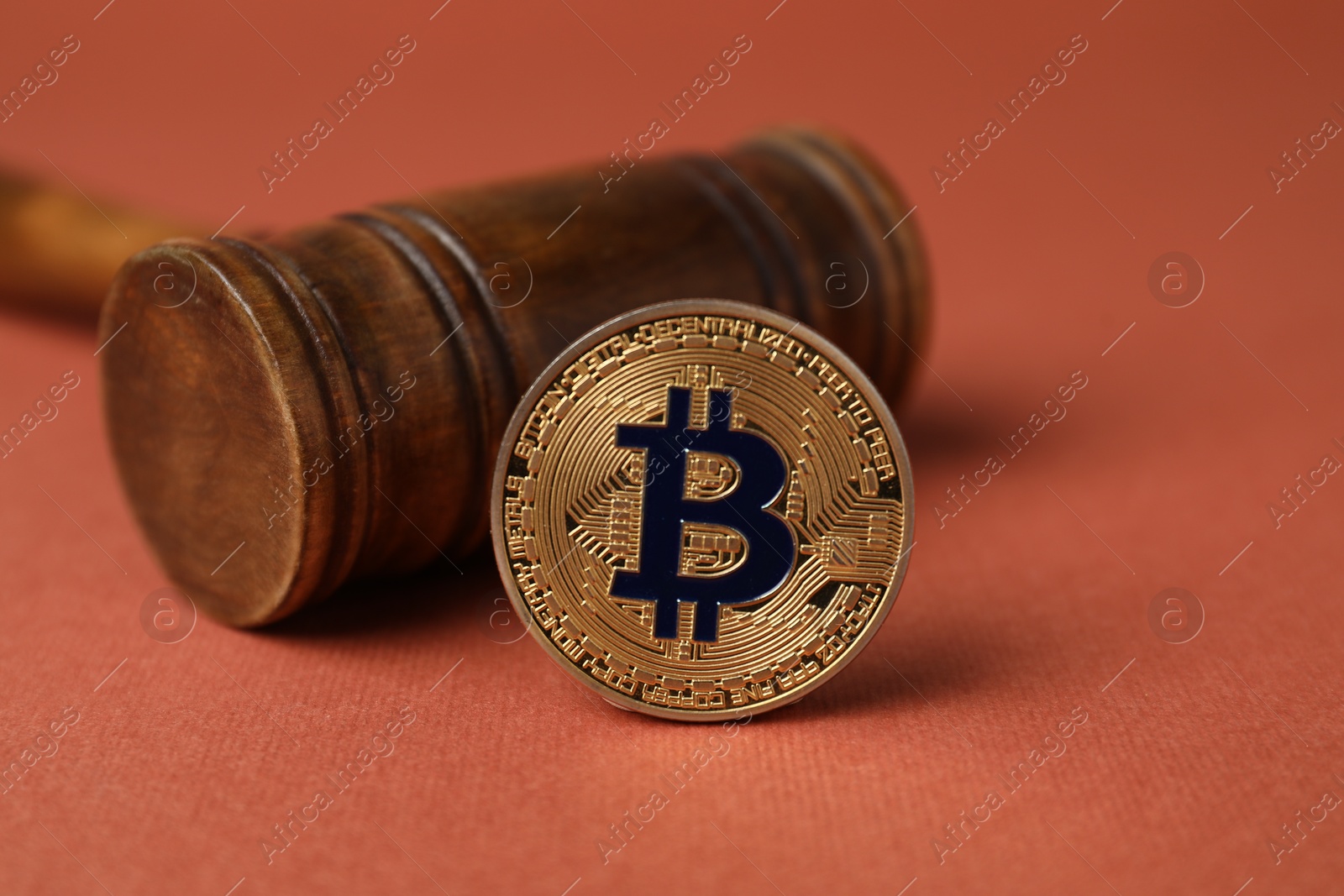 Cryptocurrency. Bitcoin and judge's gavel on red-brown background, closeup Photo of Cryptocurrency. Bitcoin and judge's gavel on red-brown background, closeup
