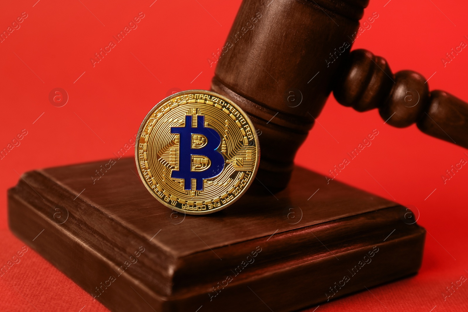 Cryptocurrency. Bitcoin and judge's gavel on red background, closeup Photo of Cryptocurrency. Bitcoin and judge's gavel on red background, closeup