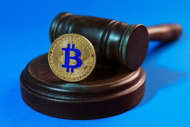 Photo of Cryptocurrency. Bitcoin and judge's gavel on light blue background, closeup. Color toned effect