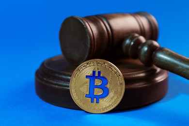 Photo of Cryptocurrency. Bitcoin and judge's gavel on light blue background, closeup. Color toned effect