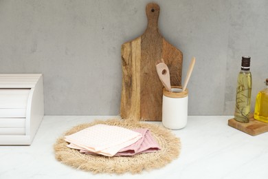 Photo of Clean waffle towels, utensils and cutting board on countertop in kitchen
