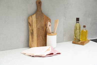 Photo of Clean waffle towels, utensils and cutting board on countertop in kitchen