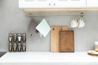 Photo of Clean waffle towels, cups, cutting boards and spices in kitchen