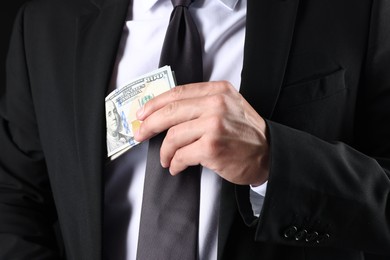 Photo of Man putting dollars in pocket, closeup view