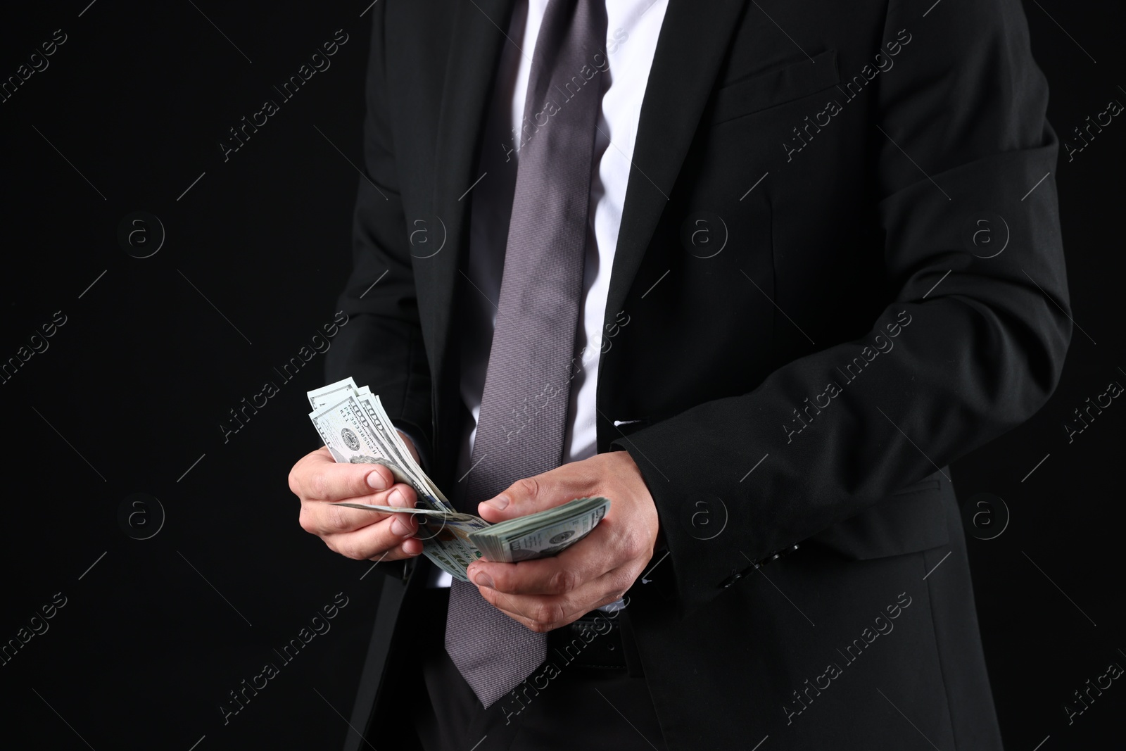 Man with dollar bills on black background, closeup Photo of Man with dollar bills on black background, closeup
