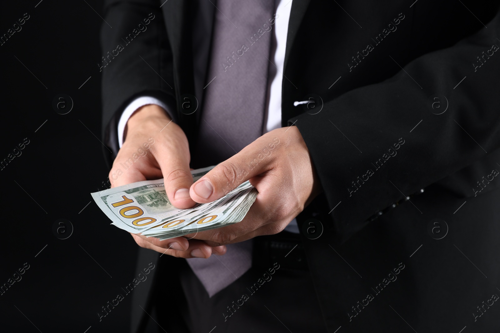 Man with dollar bills on black background, closeup Photo of Man with dollar bills on black background, closeup