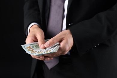 Photo of Man with dollar bills on black background, closeup