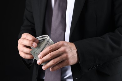 Photo of Man with dollar bills on black background, closeup