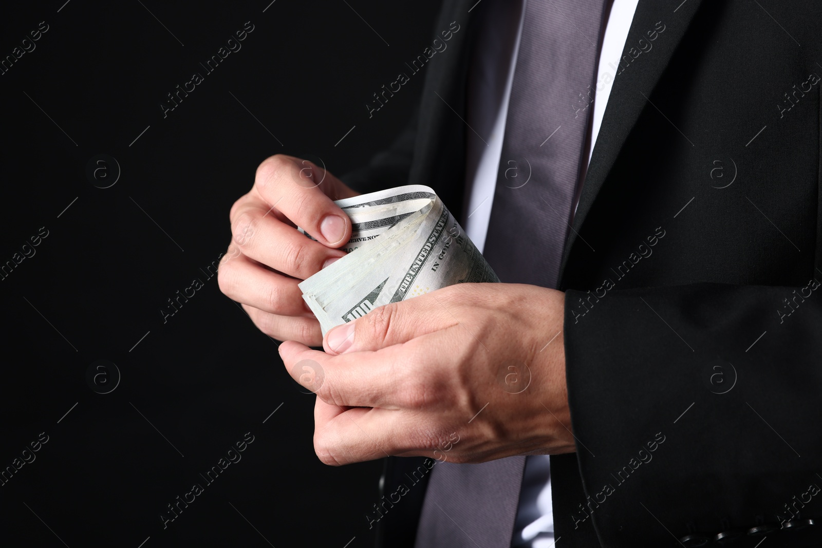 Man with dollar bills on black background, closeup Photo of Man with dollar bills on black background, closeup