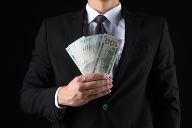 Photo of Man with dollar bills on black background, closeup