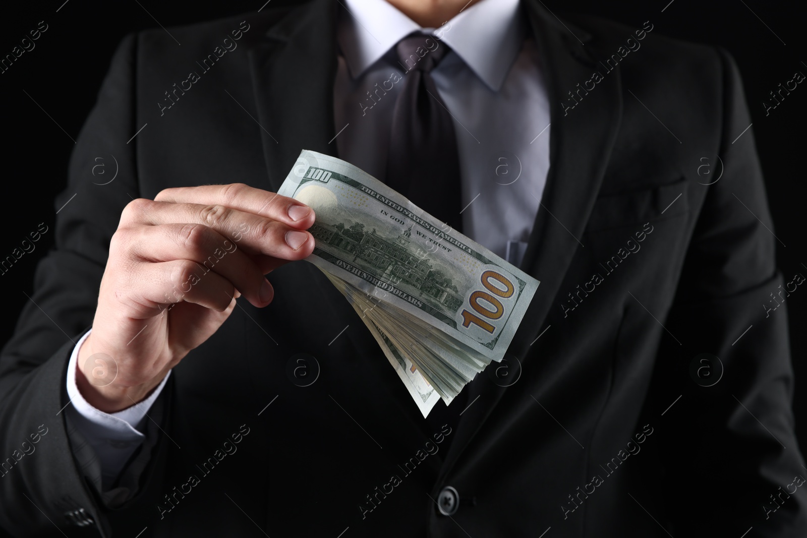 Man with dollar bills on black background, closeup Photo of Man with dollar bills on black background, closeup