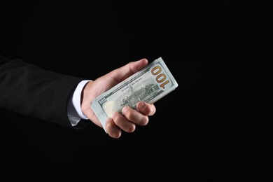 Photo of Man with dollar bills on black background, closeup