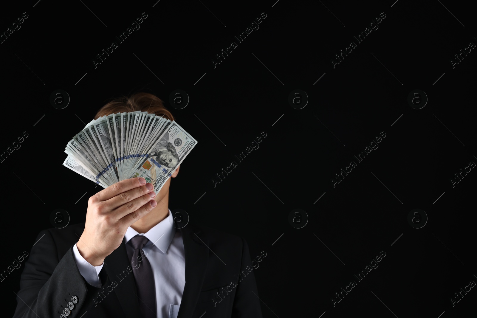 Man with dollar bills on black background, space for text Photo of Man with dollar bills on black background, space for text
