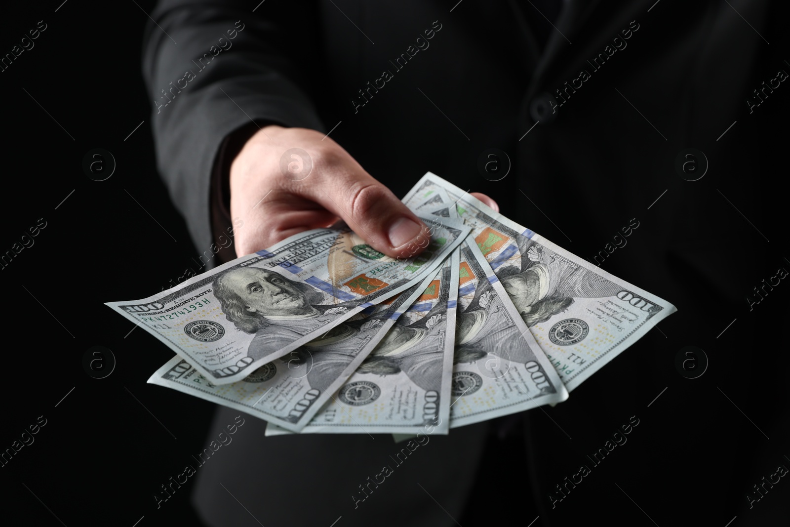 Man with dollar bills on black background, closeup Photo of Man with dollar bills on black background, closeup
