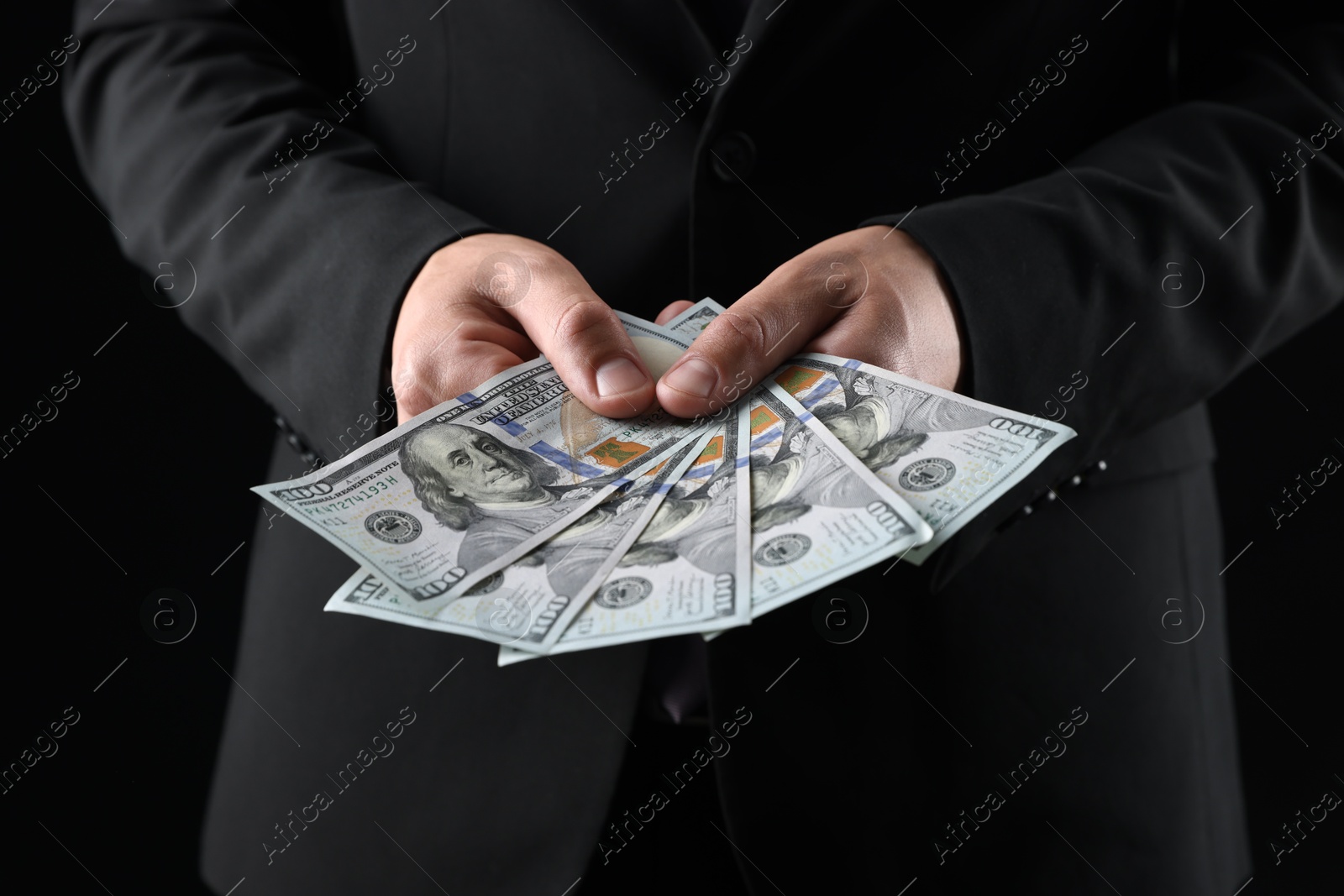 Man with dollar bills on black background, closeup Photo of Man with dollar bills on black background, closeup