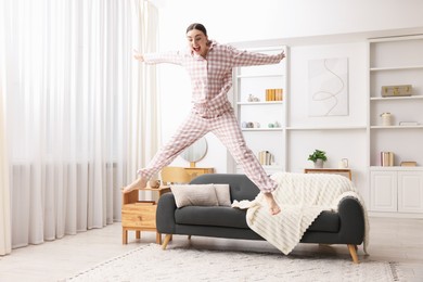 Photo of Happy woman in pyjama jumping at home