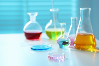 Photo of Laboratory glassware with different samples on light table, closeup