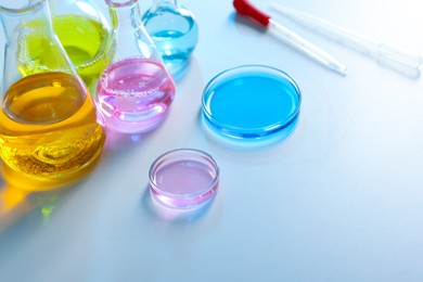 Photo of Laboratory glassware with different samples on light table, closeup