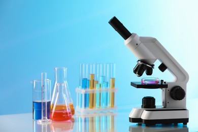 Photo of Laboratory glassware with different samples and microscope on light table
