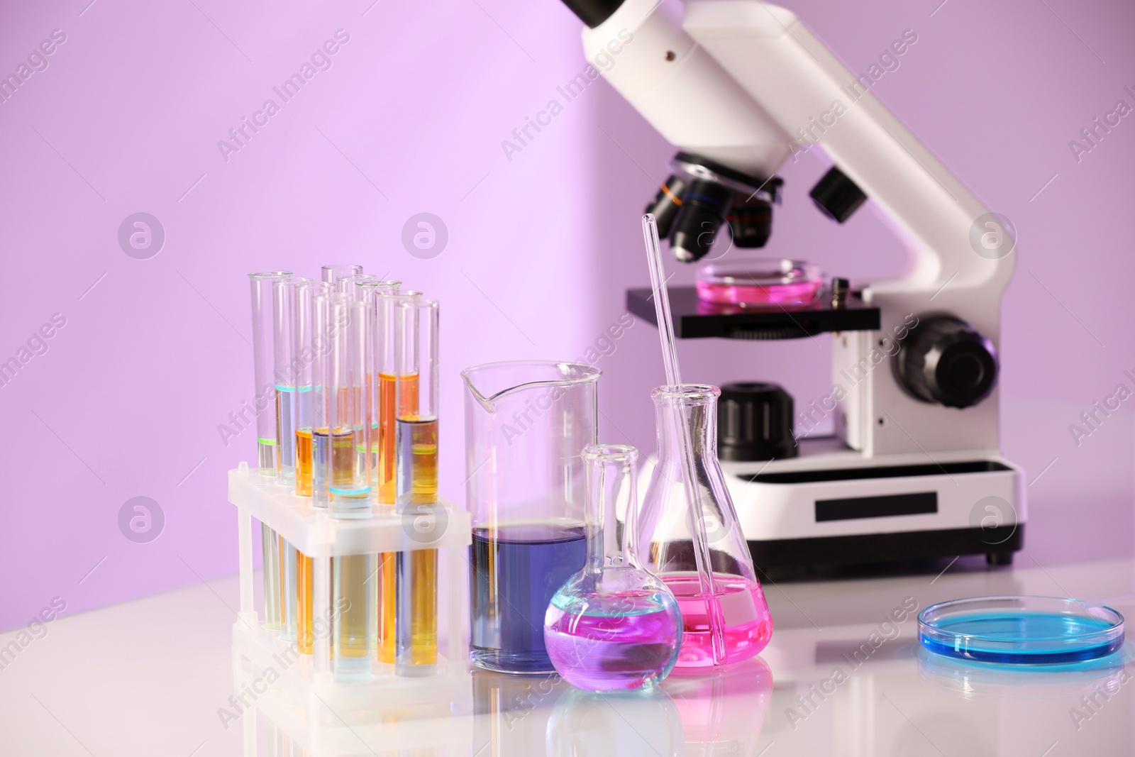 Photo of Laboratory glassware with different samples and microscope on light table