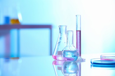 Photo of Laboratory glassware with different samples on light table. Space for text