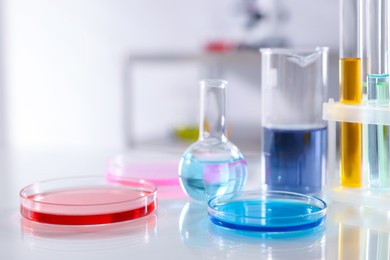 Photo of Laboratory glassware with different samples on light table, closeup. Space for text