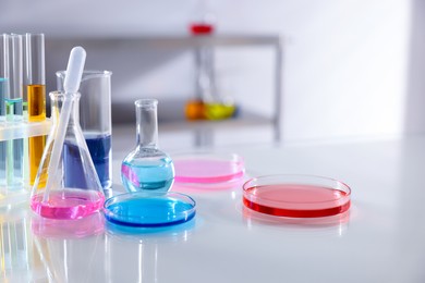 Photo of Laboratory glassware with different samples on light table, closeup. Space for text