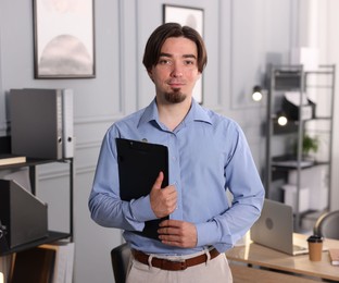 Photo of Portrait of man with clipboard in office