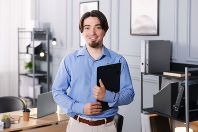 Photo of Portrait of man with clipboard in office