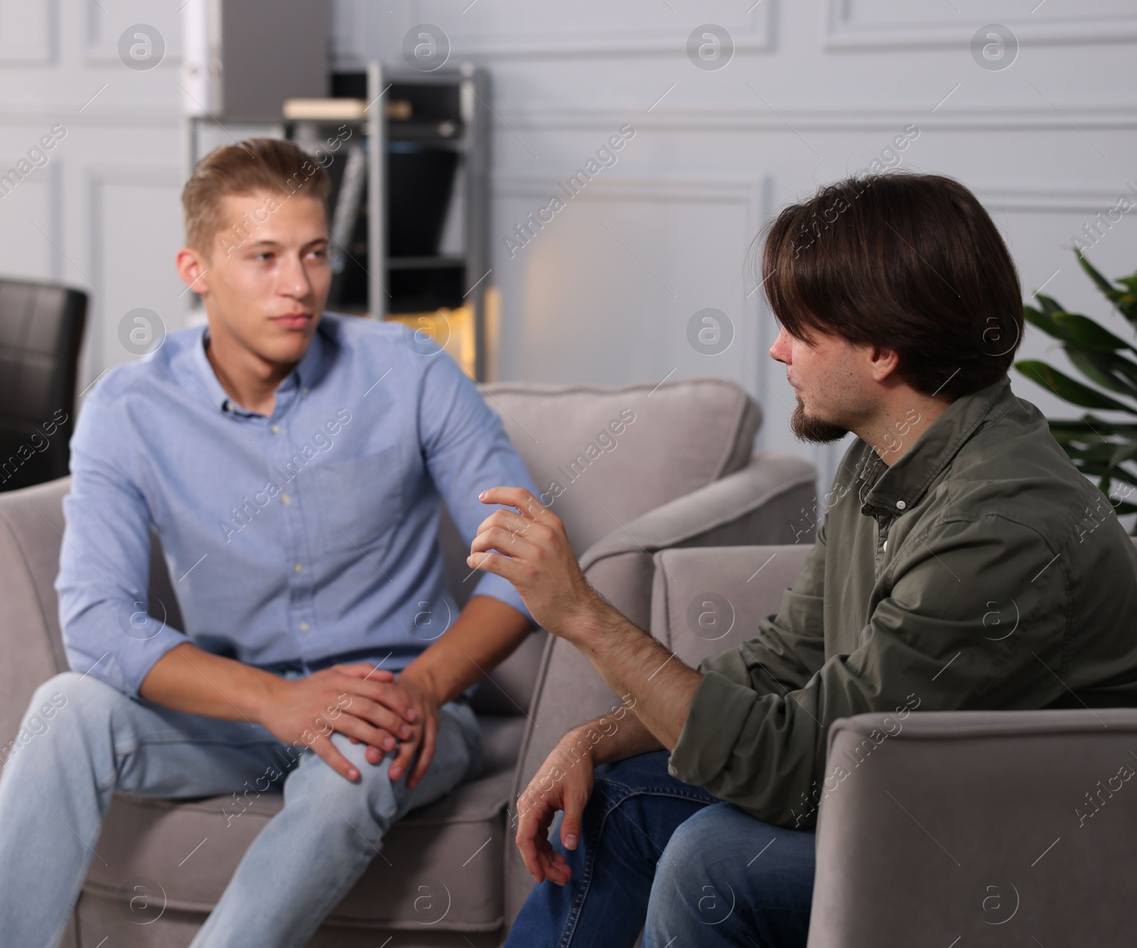 Photo of Colleagues having conversation during break in armchairs at office