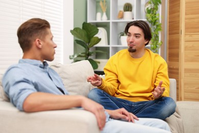 Photo of Friends having conversation on sofa at home