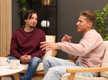 Photo of Friends talking while having tea at home