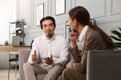 Photo of Colleagues having discussion in armchairs at office