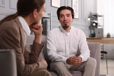 Photo of Colleagues having discussion in armchairs at office