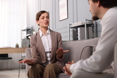 Photo of Woman having discussion with her colleague in armchairs at office