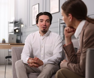 Photo of Colleagues having discussion in armchairs at office