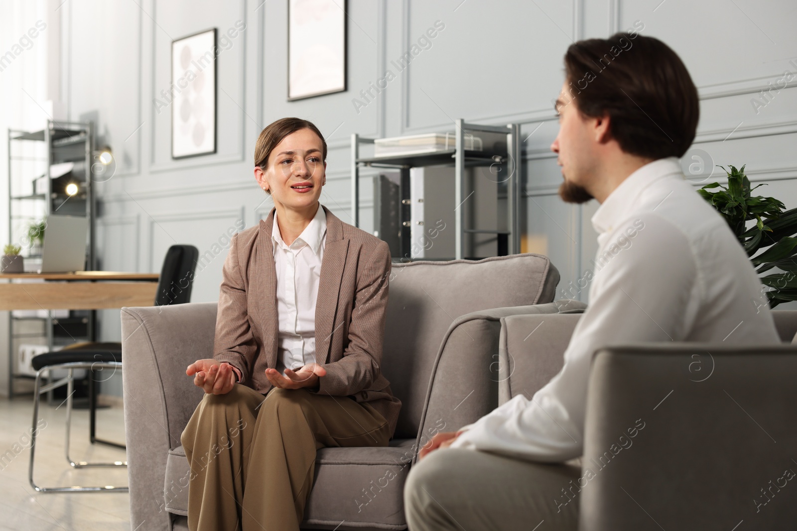 Colleagues having discussion in armchairs at office Photo of Colleagues having discussion in armchairs at office