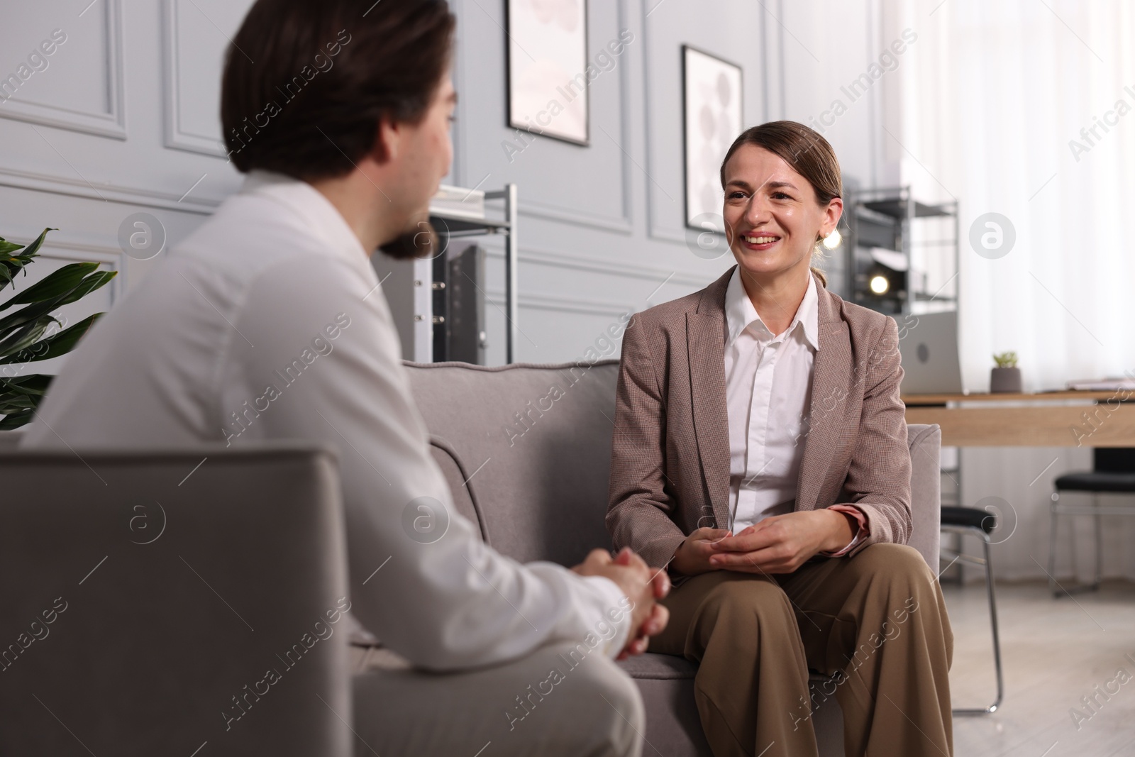Colleagues having discussion in armchairs at office Photo of Colleagues having discussion in armchairs at office